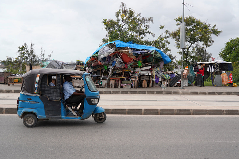 Dar Es Salam Straßenstand und Tuktuk